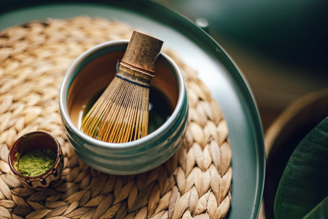 Manos sosteniendo un chawan con matcha preparado