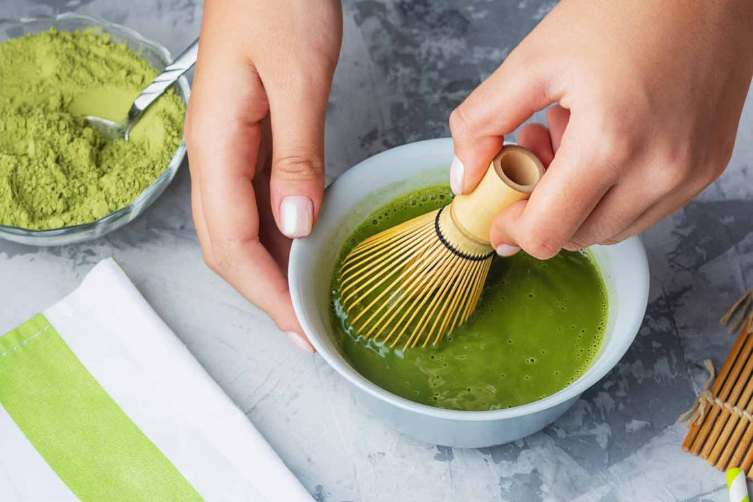 Mujer preparando matcha con chasen — beneficios del matcha para la piel
