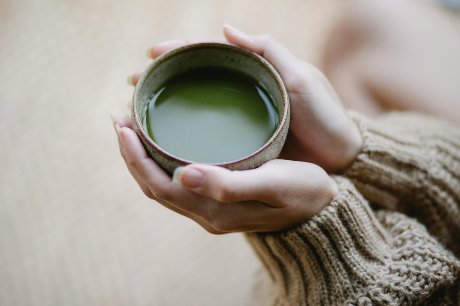 Persona sosteniendo chawan con matcha en ambiente lifestyle